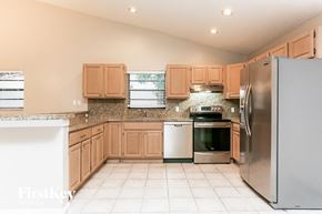Fort Lauderdale house for rent - a kitchen with wooden cabinets and stainless steel appliances