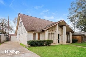 Houston house for rent - the front of a brick house with a yard and a sidewalk