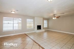 Houston house for rent - a living room with a fireplace and a ceiling fan