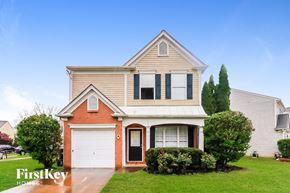 Kennesaw house for rent - a house with a white garage door in front of a green yard