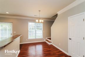 Kennesaw house for rent - an empty dining room with a staircase and a white door