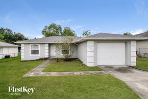 Lakeland house for rent - a white house with a lawn and a white garage door