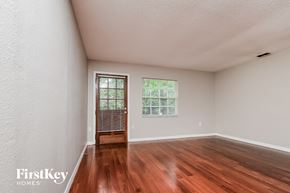 Lakeland house for rent - a spacious living room with hardwood flooring and a door to a window