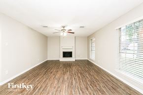 Houston house for rent - A spacious room with a fireplace and wood flooring.