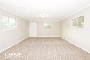 Houston house for rent - A room with a carpeted floor and a door in the middle.