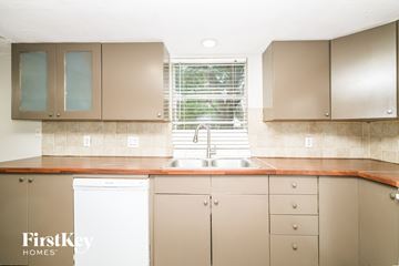Houston house for rent - A kitchen with brown cabinets and a white dishwasher.