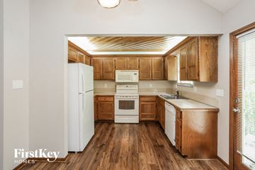 Independence house for rent - a kitchen with wooden cabinets and a white refrigerator