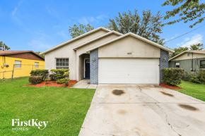 Winter Garden house for rent - a white house with a white garage door and a green lawn