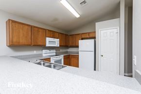 Winter Garden house for rent - a kitchen with white appliances and wooden cabinets