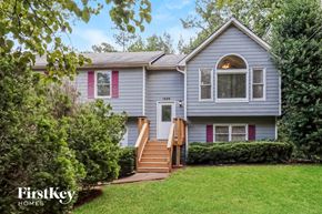 Douglasville house for rent - a blue house with pink shutters and a front yard