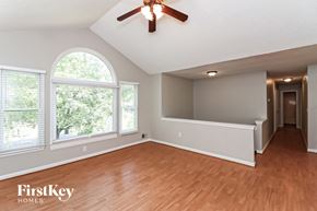 Douglasville house for rent - the living room and dining room with wood flooring and a ceiling fan