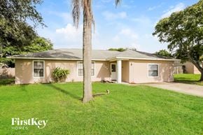 Deltona house for rent - A house with a palm tree in front of it.