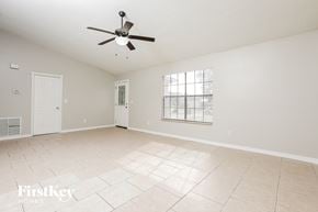 Deltona house for rent - A spacious room with a ceiling fan and a window.