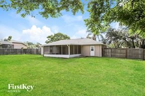 Deltona house for rent - A house with a fence and trees in the background.