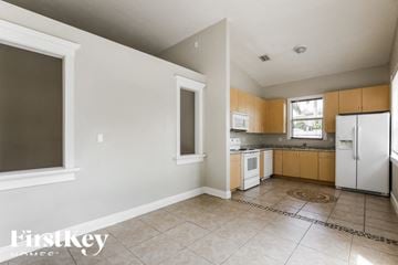 Homestead house for rent - a kitchen with white appliances and wooden cabinets