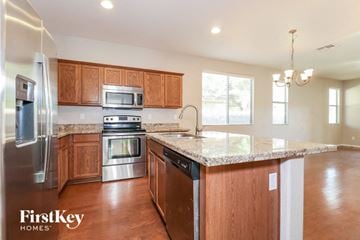 Surprise house for rent - a kitchen with wooden cabinets and granite counter tops and stainless steel appliances