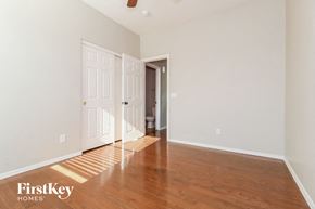 Surprise house for rent - a living room with wood flooring and white walls and a door to a hallway
