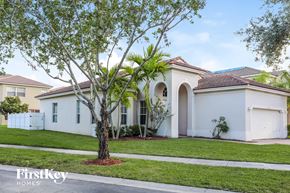 Homestead house for rent - a white house with a palm tree in front of it