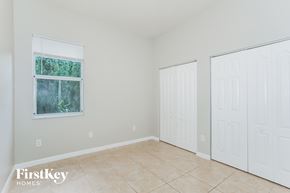Homestead house for rent - a bedroom with two closets and a tiled floor and two doors