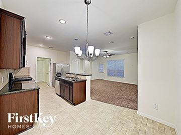 Houston house for rent - A kitchen area with a brown counter and a chandelier hanging from the ceiling.
