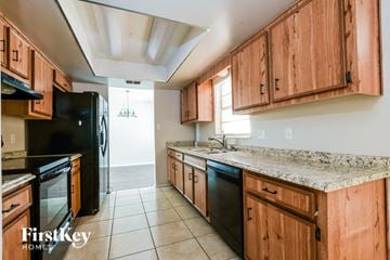 Kissimmee house for rent - A kitchen with wooden cabinets and black appliances.