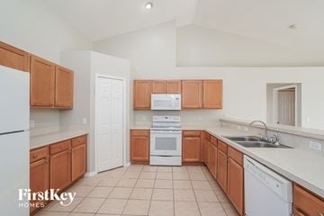 Cape Coral house for rent - a kitchen with wooden cabinets and white appliances
