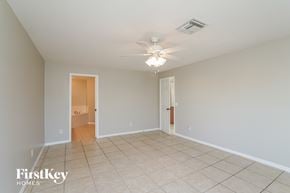 Cape Coral house for rent - a spacious living room with tile flooring and a ceiling fan