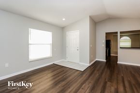 Brandon house for rent - a living room with hardwood flooring and a white door and a window