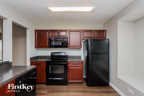 Brandon house for rent - a kitchen with black appliances and wooden cabinets