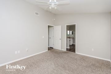 Brandon house for rent - a spacious living room with carpet and a ceiling fan