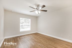 Lehigh Acres house for rent - an empty bedroom with a ceiling fan and wood floors