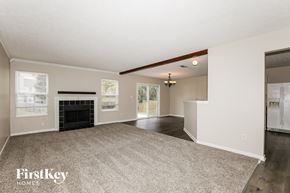 Westfield house for rent - A spacious living room with a fireplace and a carpeted floor.