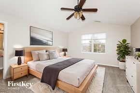 Westfield house for rent - A bedroom with a large bed, a ceiling fan, and a potted plant.
