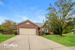 Noblesville house for rent - A house with a garage and a tree in front.