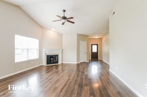 Noblesville house for rent - A spacious room with a fireplace and a ceiling fan.