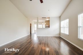 Noblesville house for rent - A spacious room with wooden floors and a ceiling fan.