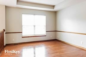 Raymore house for rent - a bedroom with wood floors and white walls and a window