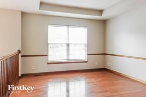 Raymore house for rent - an empty room with wood floors and a window