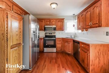 Raymore house for rent - a kitchen with wooden cabinets and stainless steel appliances