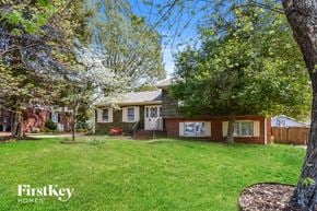 Greensboro house for rent - A house with a lawn and trees in front of it.