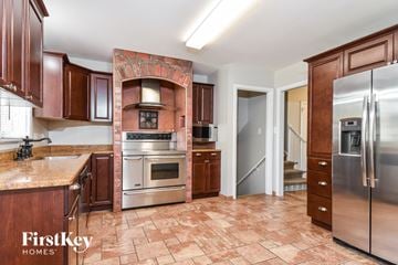 Greensboro house for rent - A kitchen with a tile floor and a brick chimney.