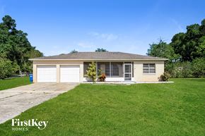Winter Haven house for rent - a small tan house with a lawn and a driveway