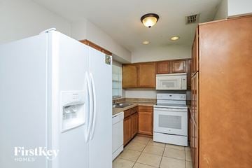 Winter Haven house for rent - a kitchen with white appliances and wooden cabinets
