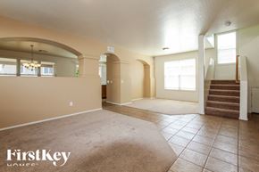 Surprise house for rent - A spacious room with a staircase and a rug on the floor.