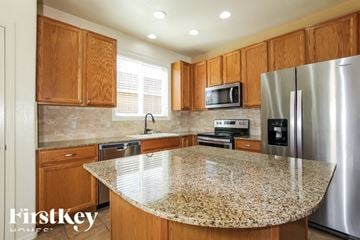 Surprise house for rent - A kitchen with wooden cabinets and granite countertops.