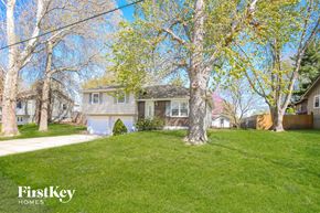 Excelsior Springs house for rent - a blue house on a green lawn with trees