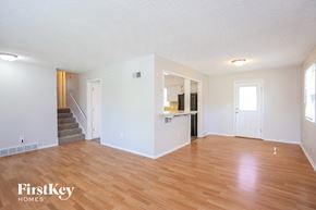 Excelsior Springs house for rent - the living room and kitchen of an empty house with wood flooring