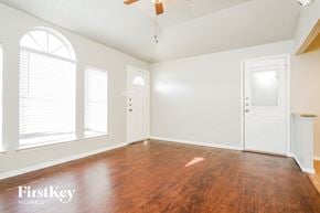 Arlington house for rent - A room with wooden floors and white walls, with a ceiling fan and two doors.