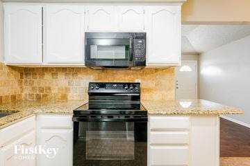 Arlington house for rent - A kitchen with a black microwave above a black stove.