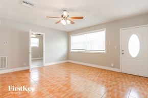 North Lauderdale house for rent - an empty living room with a ceiling fan and a window